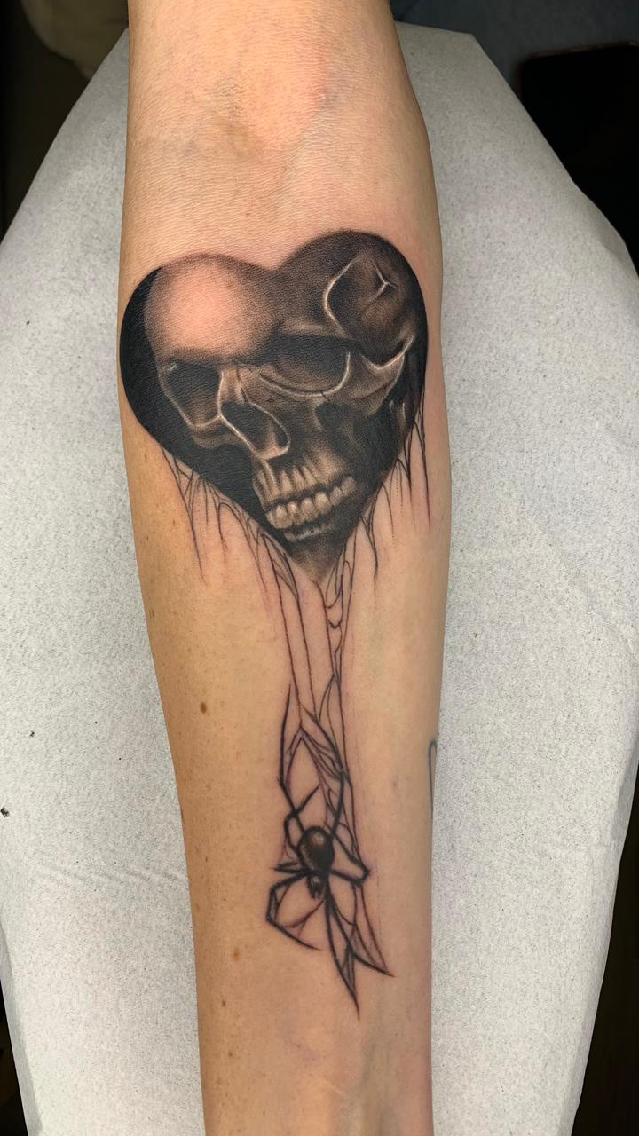 Tatuagem Blackwork Coração com Caveiras & Aranha na região antebraço feita por Juh Godoy em Porto Alegre