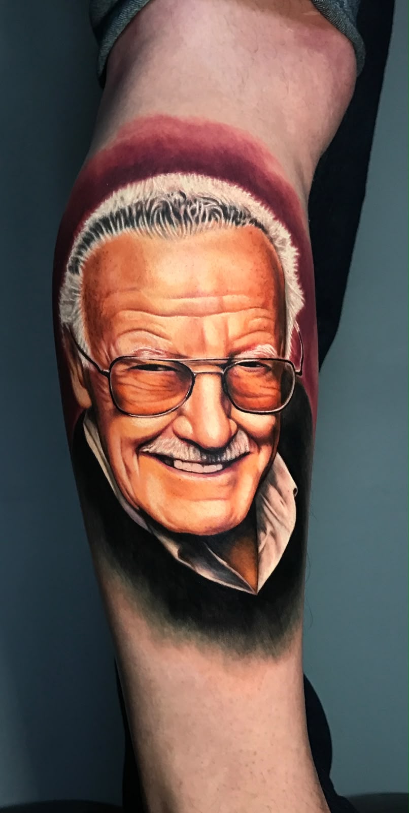 Tatuagem Realismo Colorido Stan Lee na região panturrilha feita por Bagé em Porto Alegre