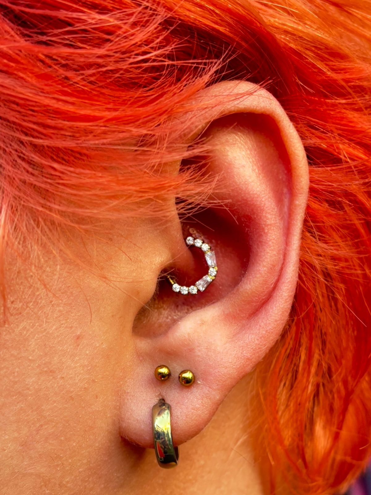 Daith cravejado e lóbulos com joias douradas
