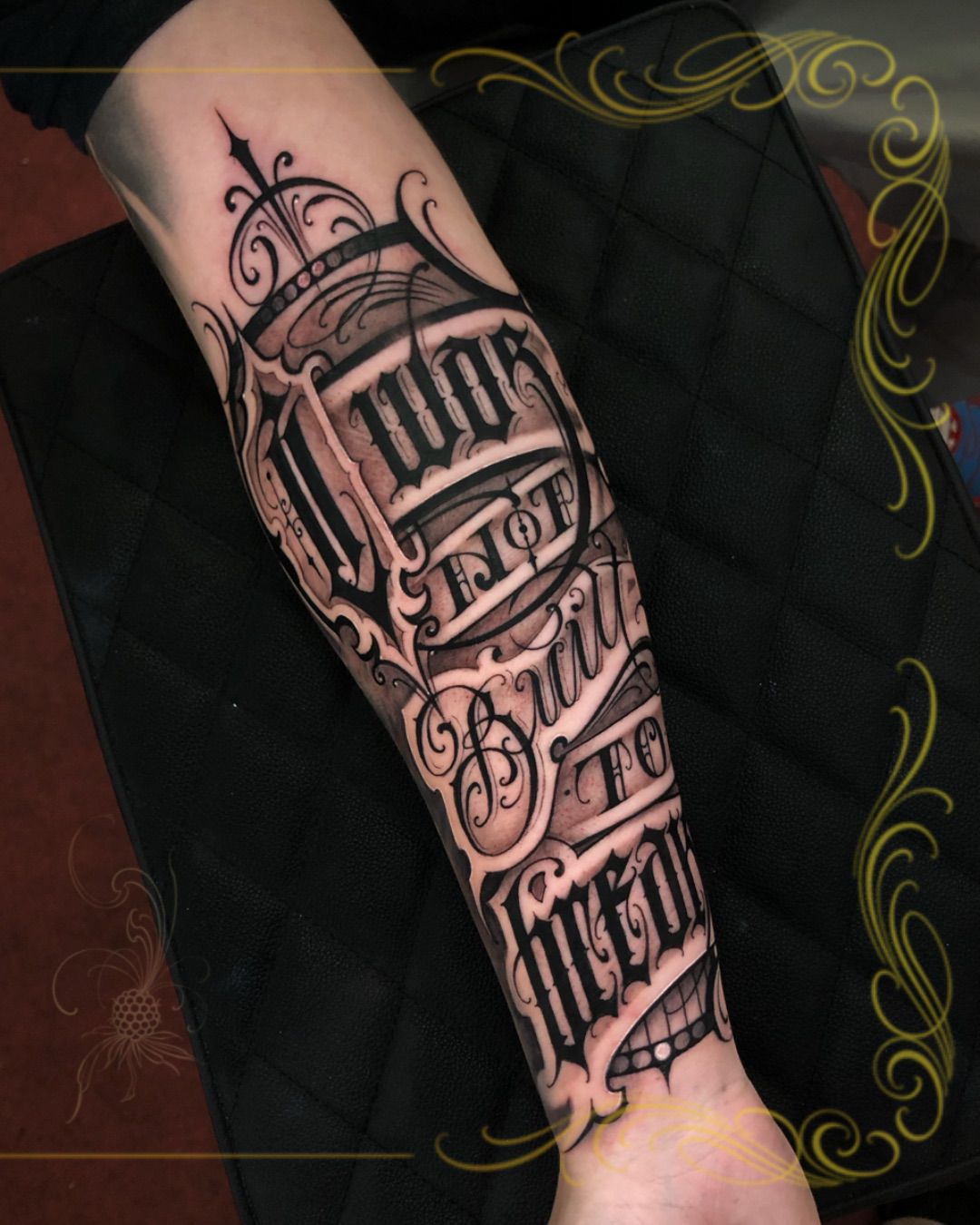 Tatuagem Lettering Built to Survive na região antebraço feita por Dênis Navarro em Porto Alegre