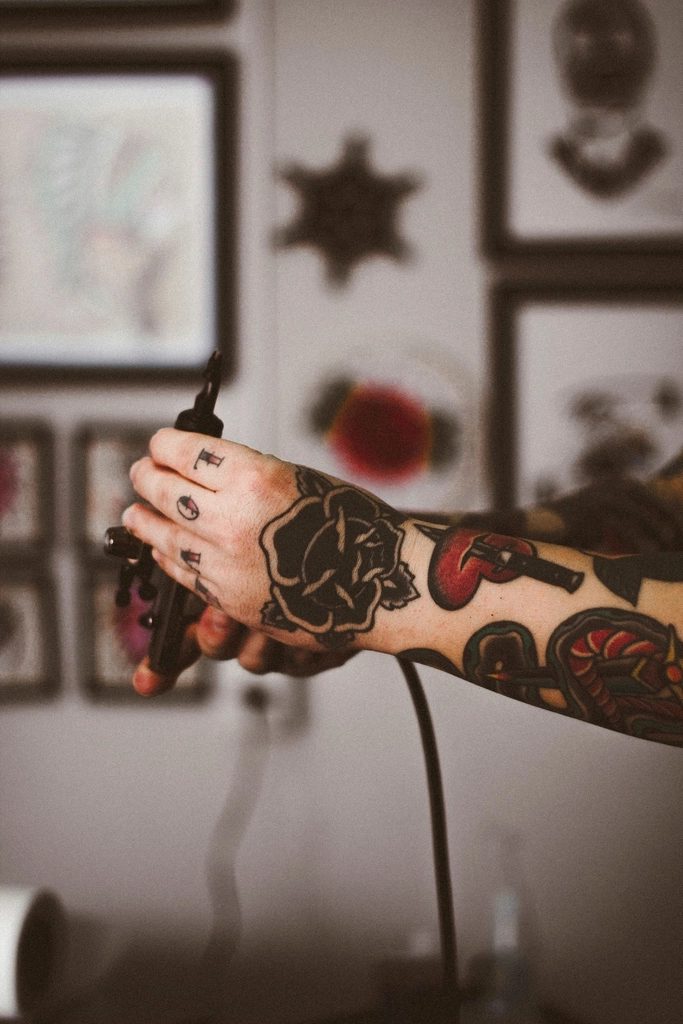 Antebraço tatuado apoiado, detalhe de traço e sombreado